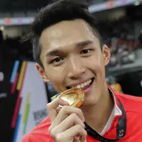 Pebulu tangkis putra Indonesia Jonatan Christie mengigit medali emas merayakan kemenangan pada final tunggal putra SEA Games 2017 melawan Khosit Phetpradab dari Thailand di Axiata Arena, Malaysia, Selasa (29/8). (Liputan6.com/Faizal Fanani)