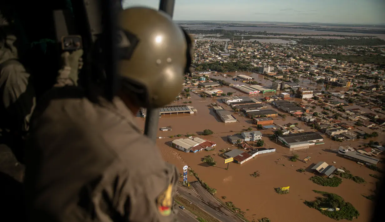 Seorang anggota militer mengamati dari helikopter jalanan yang terendam banjir di kota El Dorado do Sul, negara bagian Rio Grande do Sul, Brasil, pada tanggal 8 Mei 2024. (Carlos FABAL/AFP)