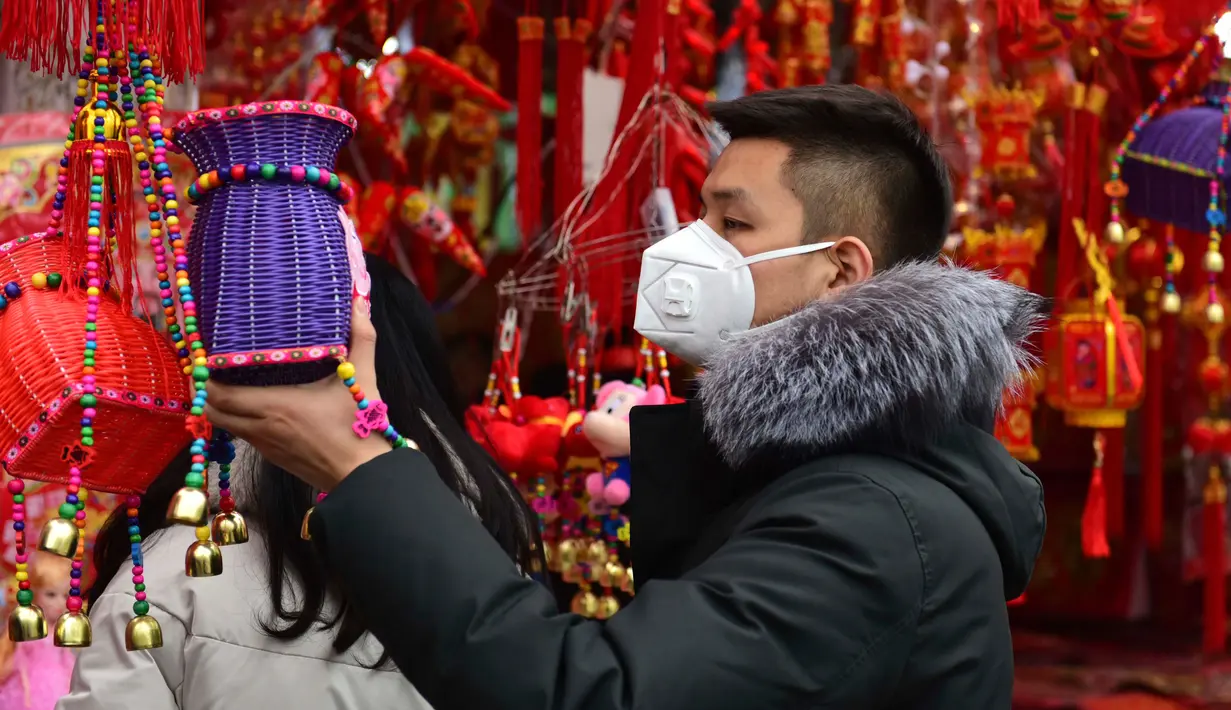 Seorang pria berbelanja dekorasi untuk perayaan Tahun Baru  Imlek di sebuah pasar di Provinsi Anhui, China, 23 Januari 2020. China menutup sebuah kota berpenduduk lebih dari 11 juta orang dalam upaya memerangi wabah virus corona, tindakan yang belum pernah terjadi sebelumnya.  (AP/Mark Schiefelbein)