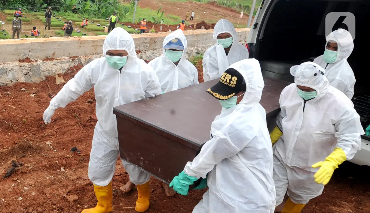 Petugas mengangkat peti jenazah korban Covid-19 di TPU Jombang, Tangerang Selatan, Senin (18/1/2020). 17 pelanggar PSBB tersebut dihukum untuk berdoa di makam korban Covid-19. (merdeka.com/Arie Basuki)