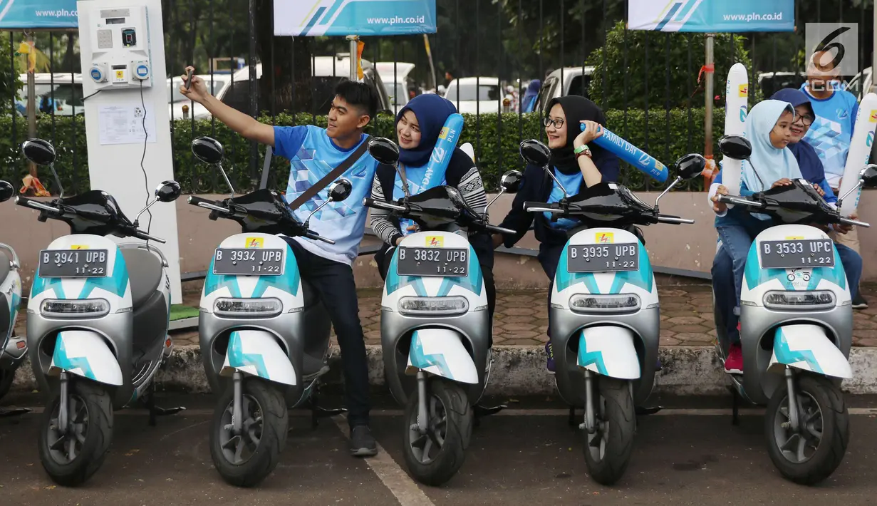 Warga berswafoto diatas motor listrik yang dipamerkan di Kawasan JCC di Jakarta, Minggu (3/12). (Liputan6.com/Angga Yuniar)