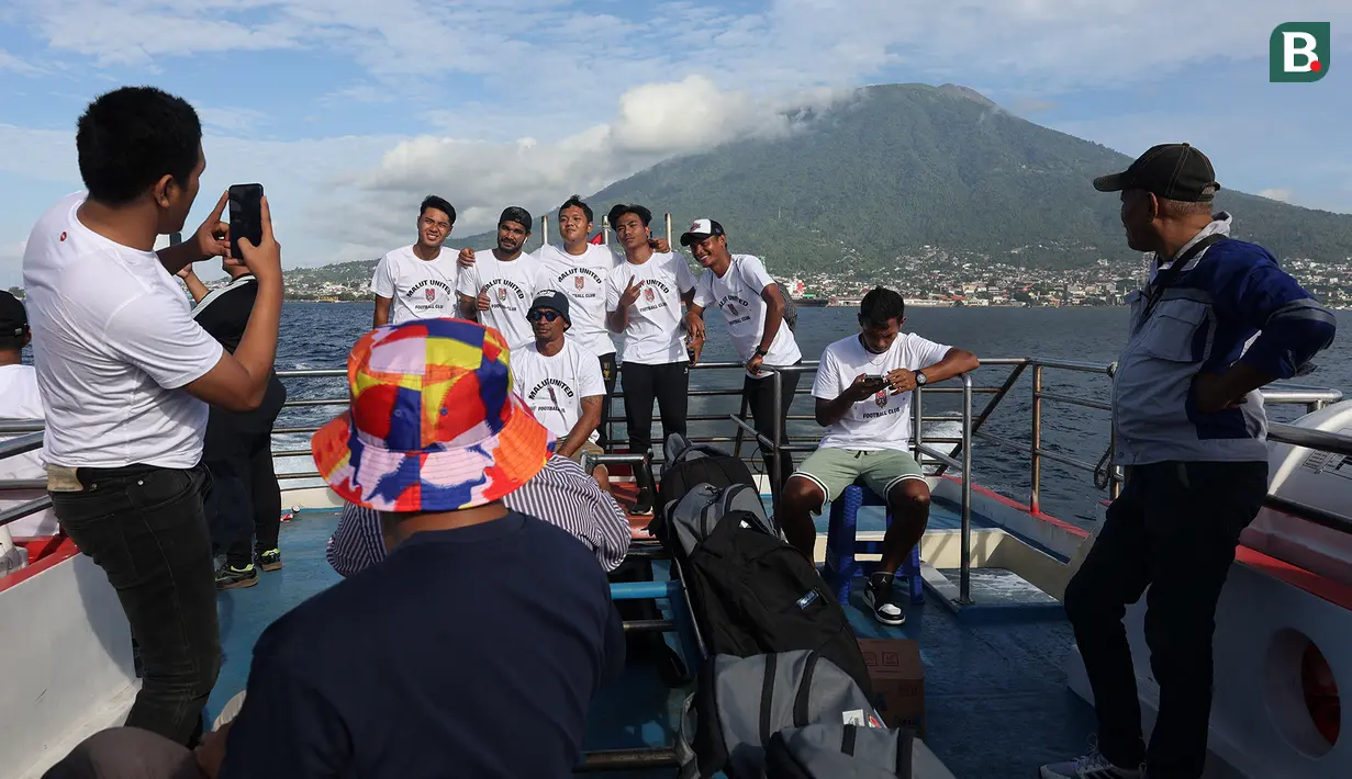 Sejumlah pemain dan staf Malut United berfoto bersama di atas kapal ferry dengan latar belakang gunung ketika menuju Tidore, Maluku Utara. (Bola.com/Okie Prabhowo)