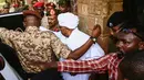 Mantan Presiden Sudan, Omar al-Bashir, dikawal setelah menghadap jaksa untuk pembacaan dakwaan terkait kasus korupsi di ibu kota Khartoum, Minggu (16/6/2019). Ini merupakan penampilan pertamanya di hadapan publik sejak kudeta penggulingan dirinya pada April lalu. (Yasuyoshi CHIBA/AFP)