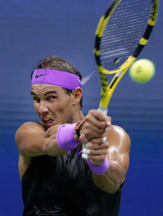 Petenis Spanyol, Rafael Nadal mengembalikan bola ke arah lawannya petenis Argentina, Diego Schwartzman  pada babak perempat final AS Terbuka 2019  di Arthur Ashe Stadium, Rabu (4/9/2019). Nadal berhasil melangkah ke semifinal dalam pertarungan tiga set dengan skor 6-4, 7-5, dan 6-2. (AP/Adam Hunger)