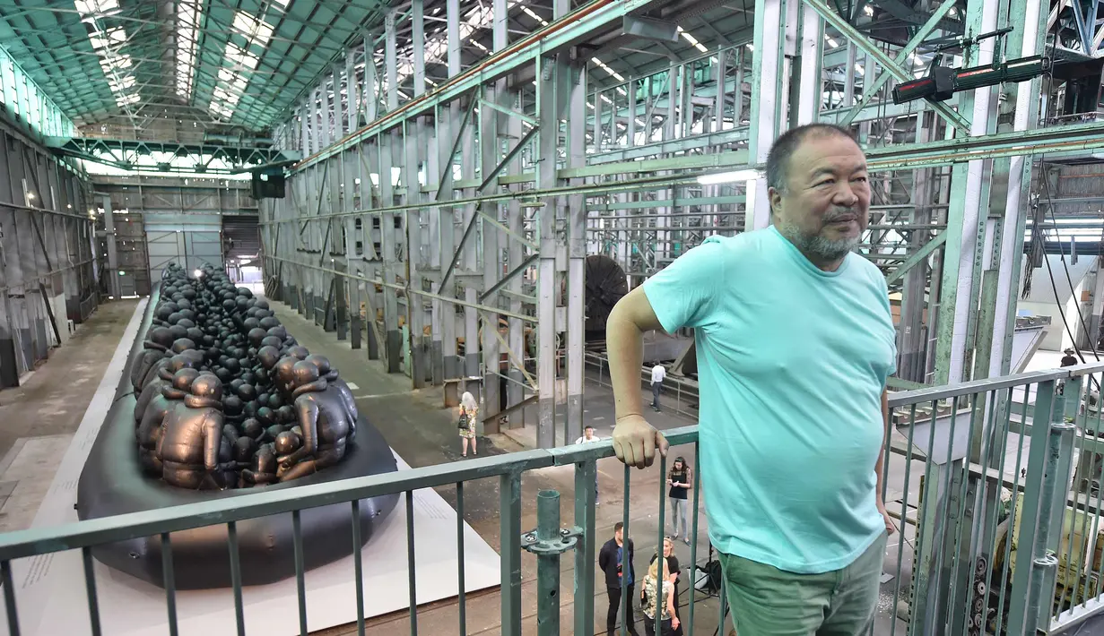 Seniman Ai Weiwei berpose di dekat karyanya yang berjudul "Law of the Journey 2017" pada sebuah preview pers Biennale ke 21 di Sydney (12/3). Karya Ai Weiwei tersebut terbuat dari karet hitam dan dibuat di China. (AFP Photo/Peter Parks)
