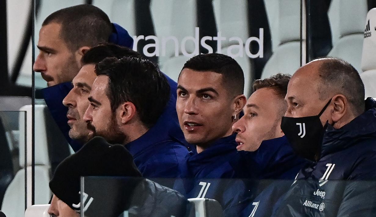 Striker Juventus, Cristiano Ronaldo (tengah) duduk di bangku cadangan sebelum dimulainya laga lanjutan Liga Italia 2020/21 menghadapi Lazio di Allianz Stadium, Turin, Sabtu (6/3/2021). Juventus menang 3-1 atas Lazio. (AFP/Miguel Medina)