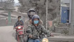 Pengendara sepeda motor memakai masker untuk mengantisipasi terhirup debu vulkanik erupsi Gunung Sinabung, di Brastagi, Karo, Sumut, Jumat (10/10). (ANTARA FOTO/Endro Lewa)