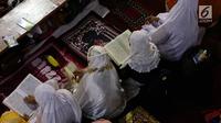 Jamaah muslimah membaca Al-Quran usai melaksanakan salat tarawih di Masjid Istiqlal, Jakarta, Jumat (26/5). Pemerintah menetapkan 1 Ramadan 1438 Hijriah jatuh pada hari Sabtu 27 Mei 2017. (Liputan6.com/Johan Tallo)