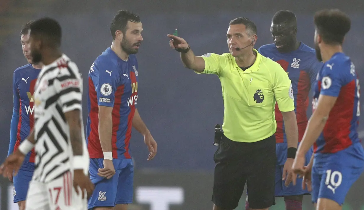 Gelandang Crystal Palace, Luka Milivojevic (kiri) mempertanyakan keputusan wasit Andre Marriner dalam laga lanjutan Liga Inggris 2020/21 pekan ke-27 melawan Manchester United di Selhurst Park, Rabu (3/3/202). Crystal Palace bermain imbang 0-0 dengan Manchester United. (AFP/Adrian Dennis/Pool)