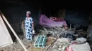 BPBD bersama perangkat kecamatan masih melakukan pendataan menyeluruh untuk memastikan skala kerusakan. Tampak dalam foto, seorang perempuan berdiri di dalam rumahnya yang rusak di sebuah desa yang terdampak banjir bandang di Batang Toru, Sumatera Utara, Senin 1 Desember 2025. (AP Photo/Binsar Bakkara)
