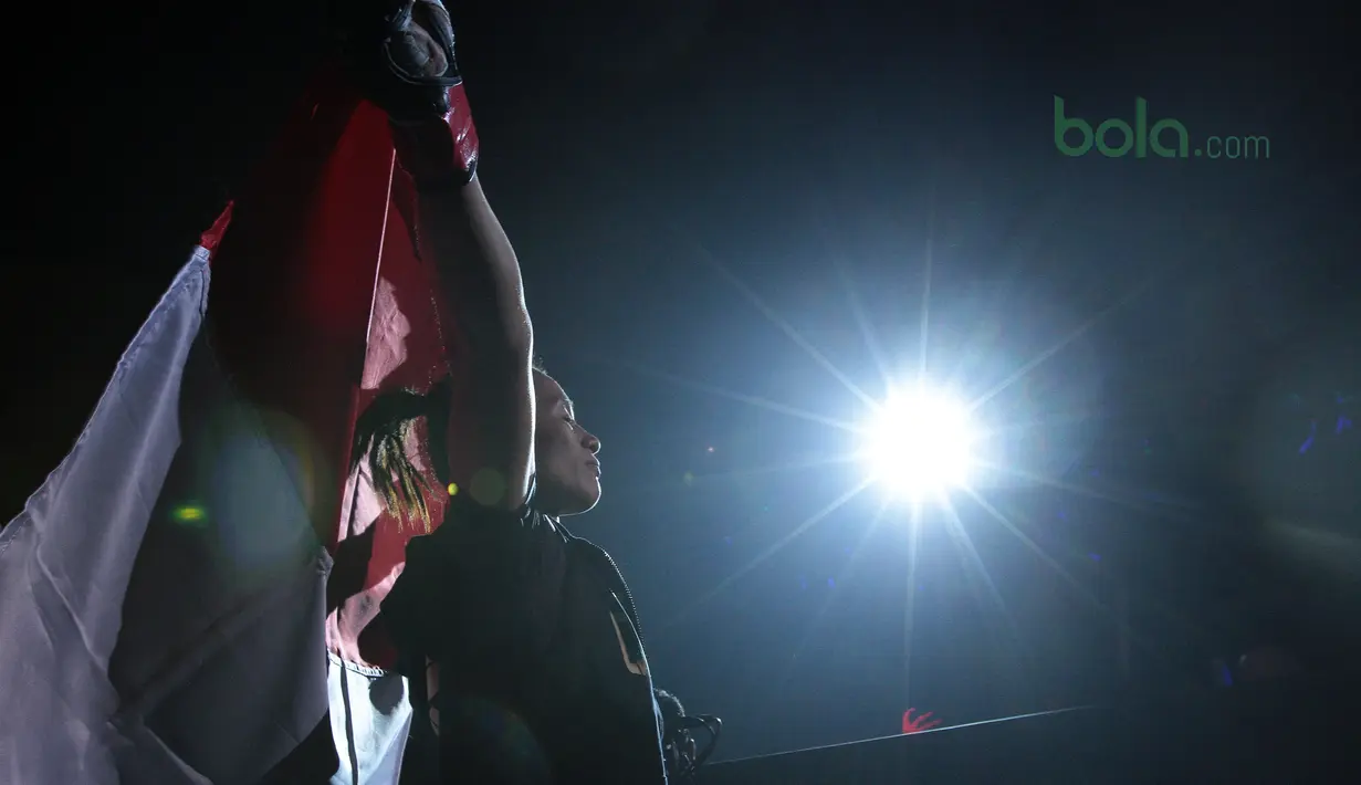 Priscilla Hertati Lumban Gaol mengibarkan bendera Merah-Putih pada ajang One Championship 2018 di Jakarta Convention Center, Sabtu (12/5/2018). Priscilla menang padan ronde pertama. (Bola.com/Nick Hanoatubun)