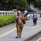 Sejumlah pekerja berjalan usai bekerja di Jalan Jenderal Sudirman, Jakarta, Selasa (10/5/2022). Pemerintah mengimbau masyarakat menerapkan bekerja dari rumah atau work from home (WFH) selama satu hingga dua pekan ke depan untuk mengantisipasi penyebaran virus corona COVID-19 usai libur Lebaran 2022. (Liputan6.com/Faizal Fanani)