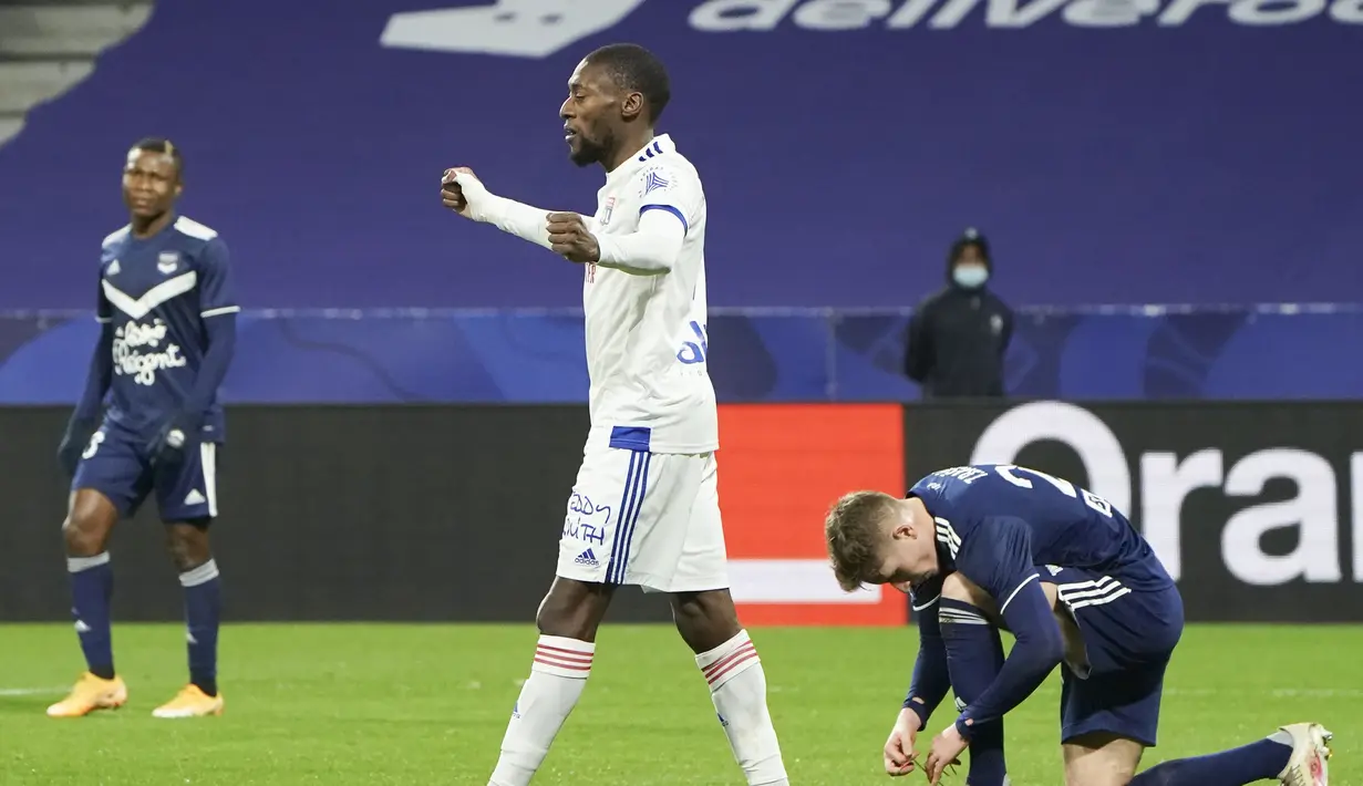 Striker Lyon, Karl Toko Ekambi (tengah) melakukan selebrasi usai mencetak gol pertama timnya ke gawang Bordeaux dalam laga lanjutan Liga Prancis 2020/21 pekan ke-22 di Groupama Stadium, Jumat (29/1/2021). Lyon menang 2-1 atas Bordeaux. (AP/Laurent Cipriani)