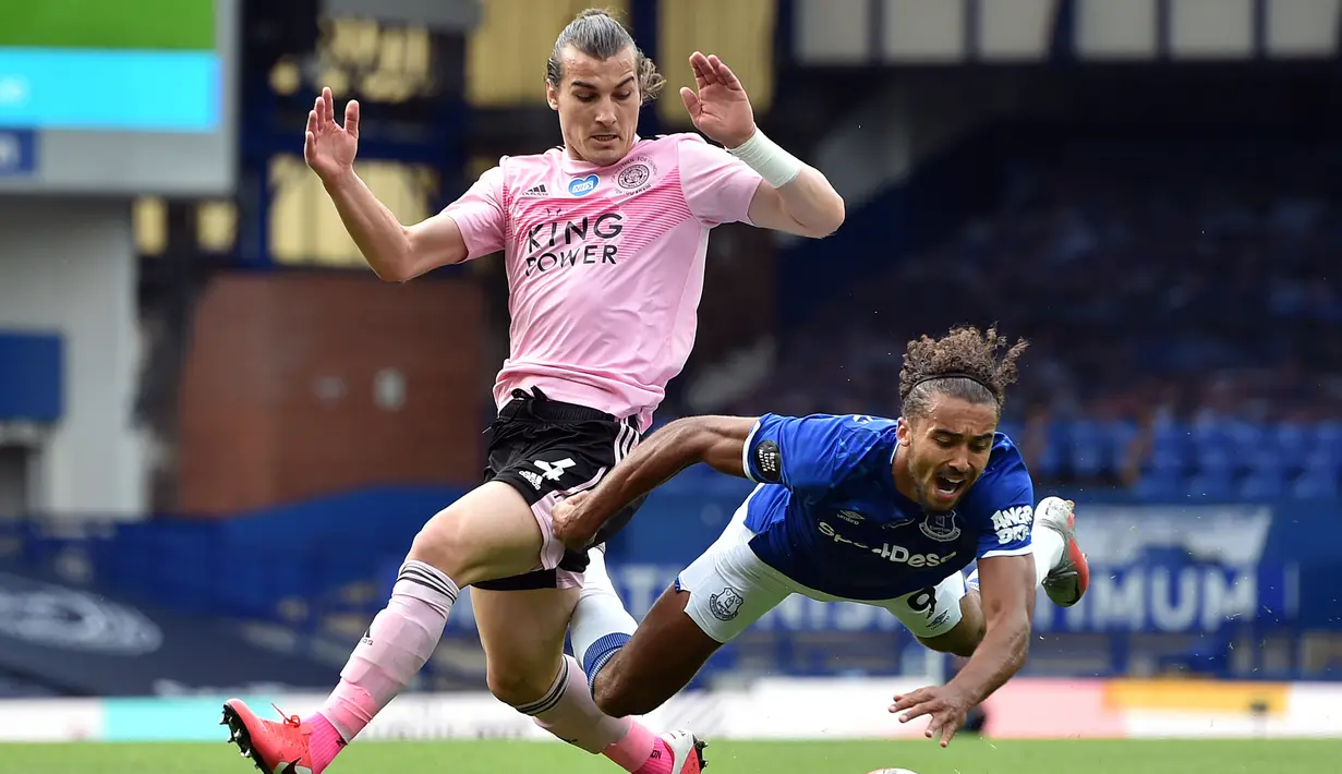 Bek Leicester City, Caglar Soyuncu, berebut bola dengan striker Everton, Dominic Calvert-Lewin, pada laga Premier League pekan ke-32 di Goodison Park, Kamis (2/7/2020) dini hari WIB. Leicester City kalah 1-2 atas Everton. (AFP/Peter Powell/pool)