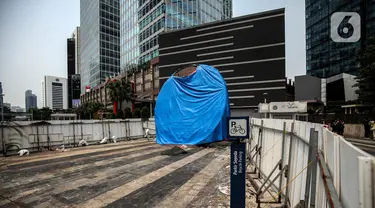 Suasana Proyek Pembangunan tugu sepeda di Jalan Jenderal Sudirman, Jakarta, Rabu (30/3/2022). Tugu yang dulu sempat boming dan digembar-gemborkan kini terlihat terhenti pengerjaannya dan hanya ditutup terpal. (Liputa6.com/Johan Tallo)