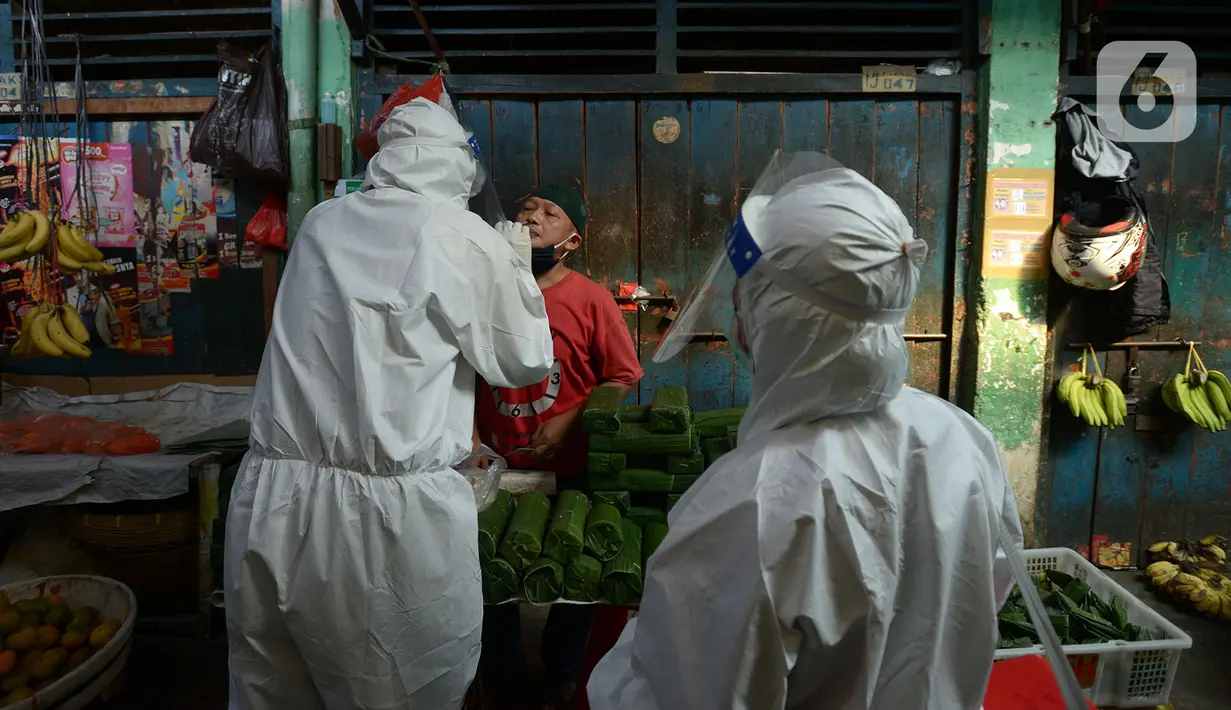 Petugas medis melakukan tes usap (swab test) ke pedagang Pasar Karang Anyar di Jakarta, Kamis (26/6/2020). Tes swab dengan metode PCR dilakukan secara masif setelah adanya pelonggaran PSBB, terutama di wilayah yang berpotensi tinggi menjadi tempat penularan Covid-19. (merdeka.com/Imam Buhori)