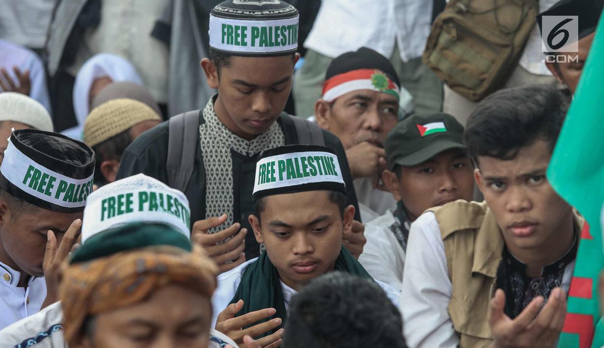 Peserta Aksi Bela Palestina berdoa di kawasan silang Monas, Jakarta, Minggu (17/12). Aksi ini juga dihadiri Ketua Umum MUI Ma'ruf Amin, hadir juga Ketua MPR RI Zulkifli Hasan dan Menteri Agama Lukman Hakim Saifuddin. (Liputan6.com/Faizal Fanani)