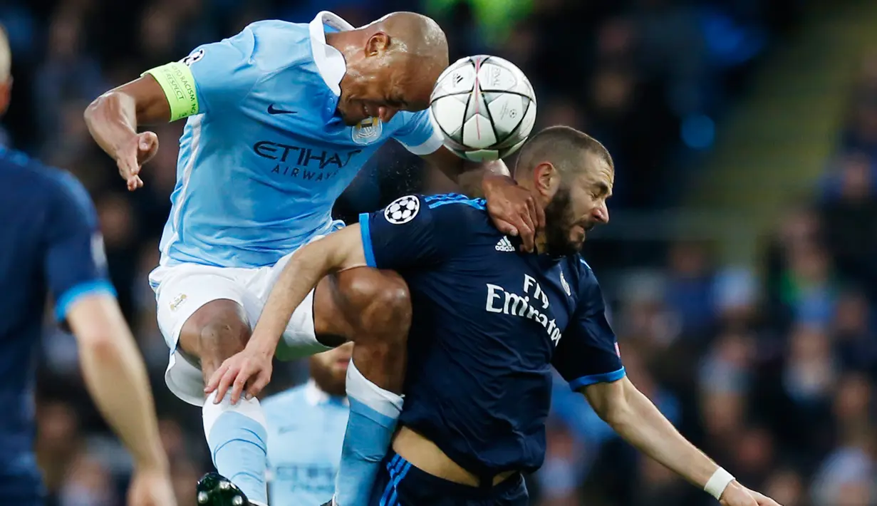 Penyerang Real Madrid, Karim Benzema (kanan) berebut bola udara dengan bek City, Vincent Kompany pada leg pertama Semifinal Liga Champions di stadion Etihad, Inggris, (27/4). Real Madrid bermain imbang dengan City dengan skor 0-0. (Reuters/Phil Noble)