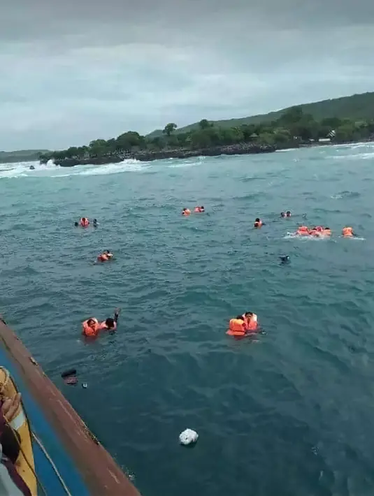 Penumpang mengapung di laut saat KM Lestari Maju tenggelam di lepas pantai Pulau Selayar, Provinsi Sulawesi Selatan, Selasa (3/7). Sebagian penumpang KM Lestari Maju yang tenggelam berhasil diselamatkan. (BNPB/AFP)