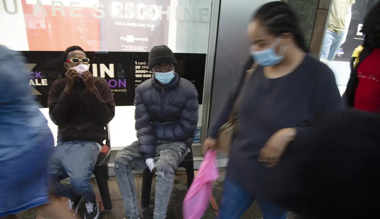 Pembeli mengenakan masker di trotoar yang ramai di Pretoria, Sabtu (27/11/2021). Saat dunia bergulat dengan munculnya varian baru COVID-19, para ilmuwan di Afrika Selatan —tempat Omicron pertama kali diidentifikasi — berjuang keras memerangi penyebarannya ke seluruh negeri. (AP Photo/Denis Farrell)