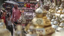 Keluarga Mesir melihat lentera tradisional yang dikenal dalam bahasa Arab sebagai "Fanous" yang dijual selama bulan suci Ramadan di Sayeda Zainab, Kairo, 17 April 2020.  Menjelang Ramadan 1441 H, warga Mesir mulai berburu lentera warna-warni di tengah pandemi corona Covid-19. (Mohamed el-Shahed/AFP)
