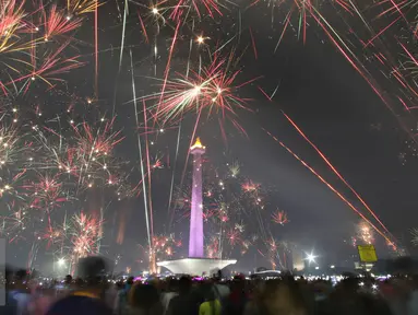 Kembang api menghiasi langit di kawasan Monas, Jakarta, Jumat (1/1). Antusiasme warga yang memadati Monas saat malam pergantian tahun membuat langit di kawasan tersebut dimeriahkan dengan pesta kembang api. (Liputan6.com/Immanuel Antonius)