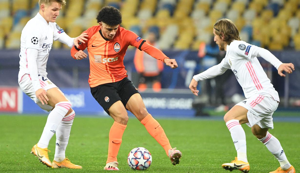 Gelandang Real Madrid, Martin Odegaard, berebut bola dengan gelandang Shakhtar Donetsk, Taison, laga lanjutan Liga Champions di NSK Olimpiyskiy, Rabu (2/12/2020) dini hari WIB. Real Madrid kalah 0-2 oleh Shakhtar Donetsk. (AFP/Sergei Supinsky)