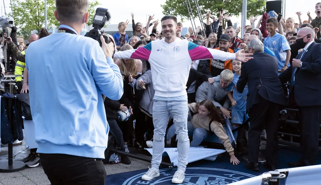 Pemain baru Manchester City, Jack Grealish berpose saat diperkenalkan di Stadion Etihad, Senin (9/8/2021). Manchester City memecahkan ekor transfer Inggris dengan mendatangkan Jack Grealish dari Aston Villa dengan harga £100 juta ($139 juta). (AP Photo/Jon Super)