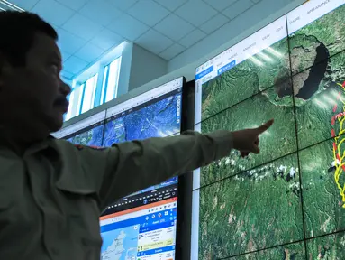 Petugas menunjukan kondisi Gunung Agung Bali yang berada di layar monitor di Gedung BNPB, Jakarta, Senin (25/9). Kepala Pusat Data Informasi dan Humas BNPB Sutopo Purwo  Nugroho mengatakan Gunung Agung dalam status awas. (Liputan6.com/Faizal Fanani)
