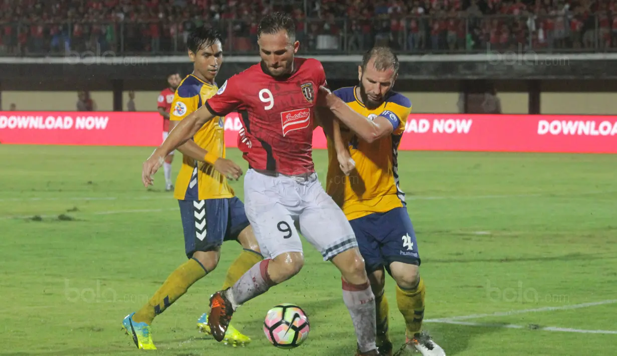 Striker Bali United, Ilija Spasojevic, menghindari kepungan pemain Tampines Rovers pada laga kualifikasi Liga Champions Asia di Stadion I Wayan Dipta, Gianyar, Selasa (16/1/2018). Bali United menang 3-1 atas Tampines Rovers.(Bola.com/Ronald Seger)