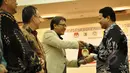 Ketua Komisi Pemilihan Umum (KPU) RI Husni Kamil Manik (kanan) menyerahkan cinderamata usai penandatanganan MoU antara KPU RI dengan sembilan perguruan tinggi di Gedung KPU, Jakarta, Kamis (12/3/2015). (Liputan6.com/Faizal Fanani)