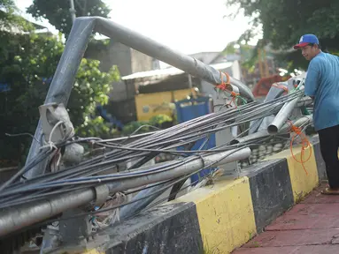 Warga berjalan di samping pagar jembatan yang rusak di kawasan Bukit Duri, Jakarta, Jumat (21/2/2020). Pagar yang rusak akibat penanganan sampah banjir tersebut hingga kini belum juga diperbaiki. (Liputan6.com/Immanuel Antonius)