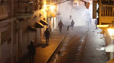 Polisi saat bentrok dengan pengunjuk rasa di Old San Juan, Puerto Rico (22/7/2019). Para pengunjuk rasa menuntut agar Gubernur Ricardo Rossello mundur  dari jabatannya setelah dalam pusaran skandal pesan teks daring tak senonoh dengan para stafnya. (AFP Photo/Joe Raedle)