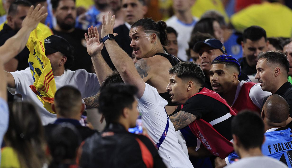 Striker Timnas Uruguay, Darwin Nunez (tengah) bersama rekan setim berusaha menghampiri suporter lawan di atas tribun penonton usai berakhirnya laga semifinal Copa America 2024 di Bank of America Stadium, Charlotte, Amerika Serikat, Kamis (11/7/2024) pagi WIB. (AFP/Getty Images/Buda Mendes)