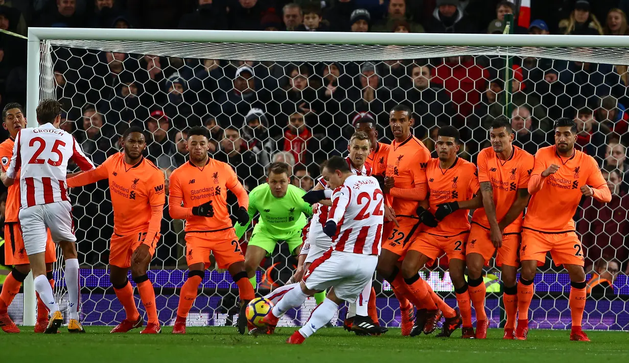 Pemain Stoke City, Xherdan Shaqiri melakukan tendangan bebas selama pekan ke-14 Premier League saat menjamu Liverpool di Bet365 Stadium, Kamis (30/11). Liverpool berhasil membantai Stoke City dengan skor 3-0. (Geoff CADDICK/AFP)