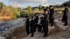 Yahudi ultraortodoks berpartisipasi dalam upacara Tashlich di tepi sungai dekat Beit Shemesh, Israel, Rabu (20/9/2023). Tashlich, yang berarti 'membuang' dalam bahasa Ibrani, adalah praktik di mana orang Yahudi pergi ke perairan besar yang mengalir dan secara simbolis 'membuang' dosa mereka dengan melemparkan sepotong roti atau makanan serupa ke dalam air. (AP Photo/Ohad Zwigenberg)
