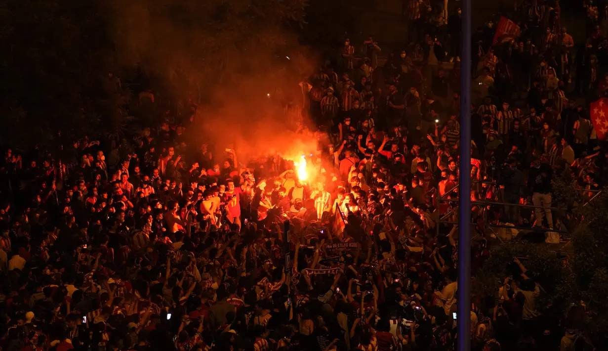 Para suporter Atletico Madrid merayakan keberhasilan tim mereka menjadi juara Liga Spanyol 2020-2021 di Madrid, Sabtu (22/5/2021). Atletico Madrid menang 2-1 atas Real Valladolid dan merebut gelar La Liga Spanyol ke-11. (AP Photo/Paul White)