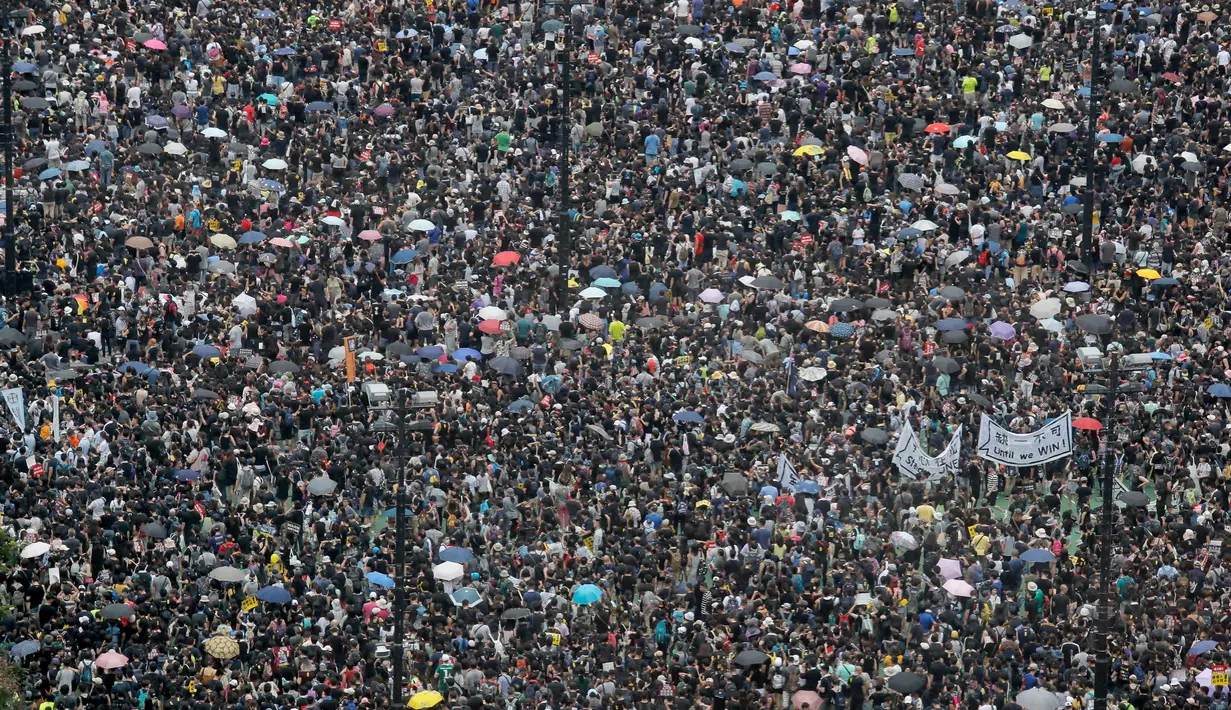 Pengunjuk rasa berkumpul di Victoria Park, Hong Kong, Minggu (18/8/2019). Puluhan ribu massa pro-demokrasi membawa payung saat hujan mengguyur Victoria Park dan sekitarnya. (AP Photo/Kin Cheung)