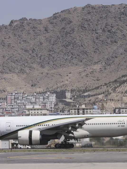 <p>Penumpang berdiri dalam antrean untuk menaiki pesawat Pakistan International Airlines (PIA) di bandara di Kabul, Senin (13/9/2021). Pesawat itu tercatat sebagai penerbangan komersial internasional pertama yang mendarat sejak Taliban merebut kembali kekuasaan di Afghanistan. (Karim SAHIB/AFP)</p>