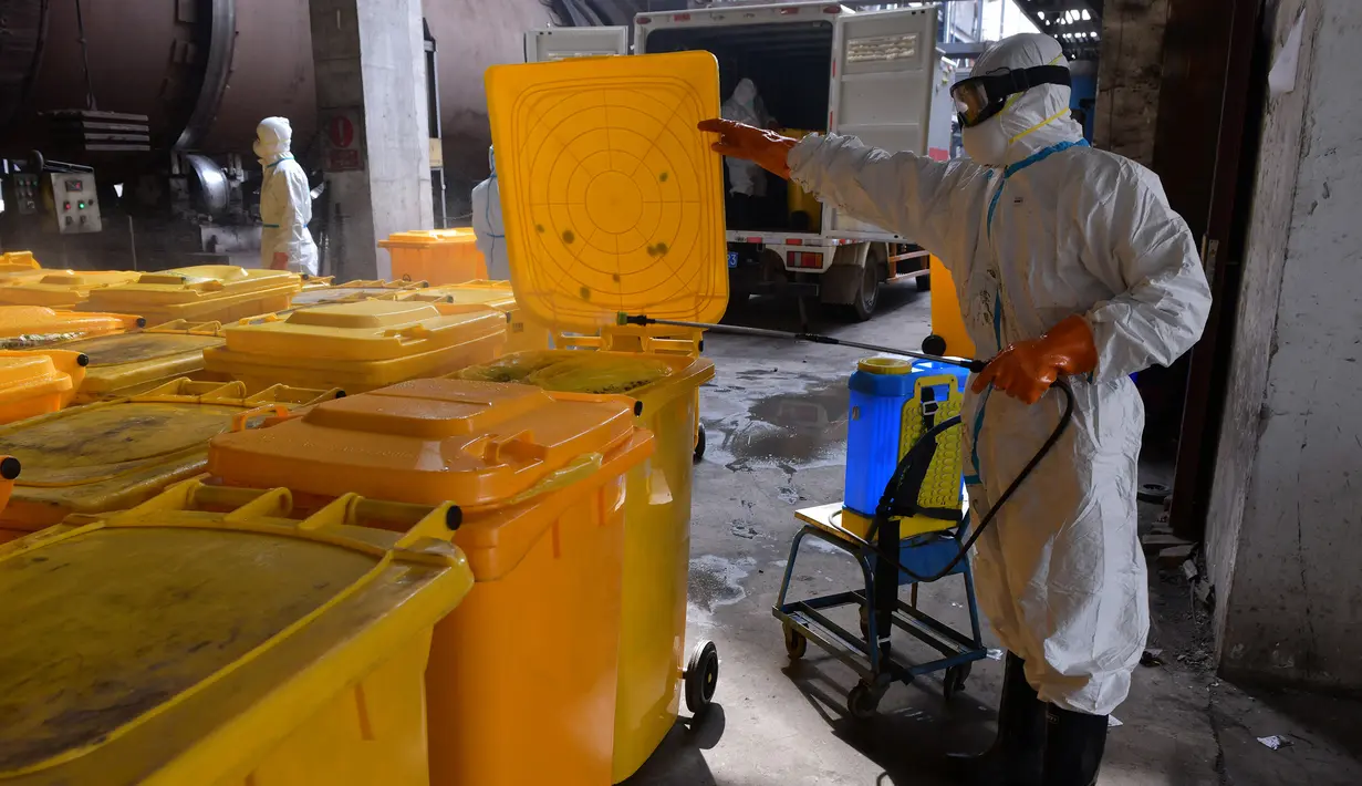 Pekerja mendisinfeksi kontainer berisi limbah medis di Wuhan Beihu Yunfeng Environmental Technology Co., Ltd. di Distrik Qingshan, Wuhan, Hubei, China, Rabu (4/3/2020). Untuk menjalankan tugasnya membuang virus corona (COVID-19), perusahaan mengubah fasilitas dan teknik pembuangan. (Xinhua/Cai Yang)