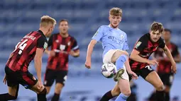 Gelandang Manchester City, Tommy Doyle mengontrol bola dari kawalan dua pemain Bournemouth pada pertandingan putaran ketiga Piala Liga Inggris di City of Manchester Stadium di Manchester, Inggris, Kamis (24/9/2020). City menang tipis atas Bournemouth 2-1. (Laurence Griffiths/Pool via AP)