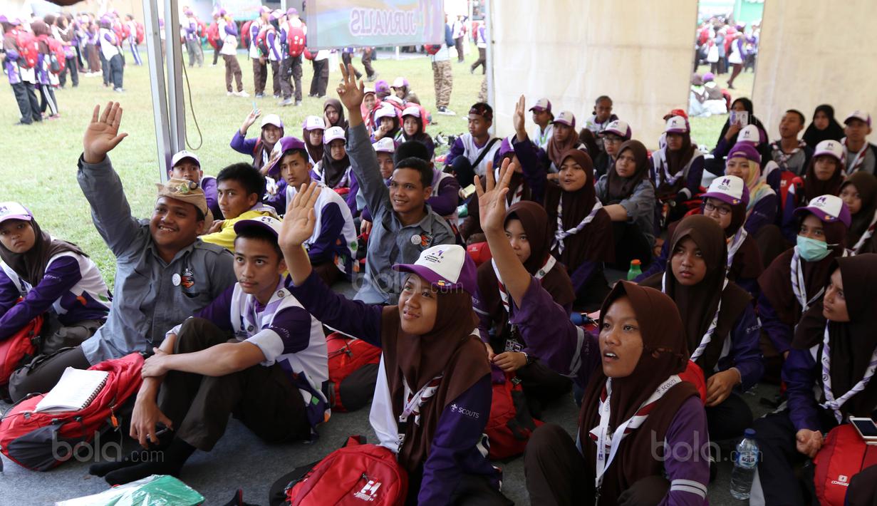 Antusias peserta Raimuna Nasional XI untuk bertanya pada kelas jurnalistik olahraga di Bumi Perkemahan Cibubur, Selasa (15/8/2017). Kegiatan ini sebagai bentuk dari pembelajaran jurnalistik olahraga. (Bola.com/Nicklas Hanoatubun)