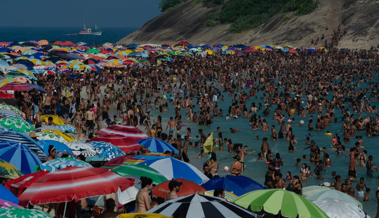 Para penjemur menikmati pantai Macumba, di zona barat Rio de Janeiro, pada 24 September 2023. (Tercio Teixeira/AFP)