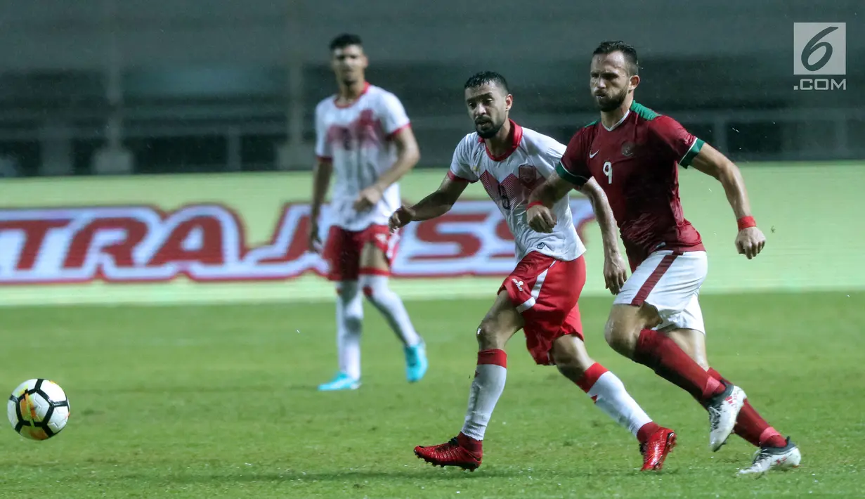 Pemain tengah Indonesia U-23, Ilija Spasojevic (kanan) berebut bola dengan pemain Bahrain pada laga PSSI Anniversary 2018 di Stadion Pakansari, Kab Bogor, Jumat (27/4). Indonesia kalah 0-1. (Liputan6.com/Helmi Fithriansyah)