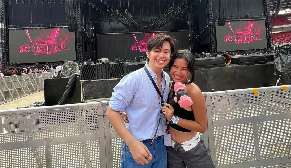 Momen Angga Yunanda dan Shenina Cinnamon nonton konser Blackpink pada Maret 2023. Diketahui Angga dan Shenina nonton konser tersebut selama dua hari. Untuk menambah keseruan, tak lupa pasangan ini membawa lighstick. Berpose manis di depan barricade dan dengan latar layar tulisan Blackpink, momen manis Angga Yunadan dan Shenina bikin netizen baper. (Liputan6.com/IG/@angga)