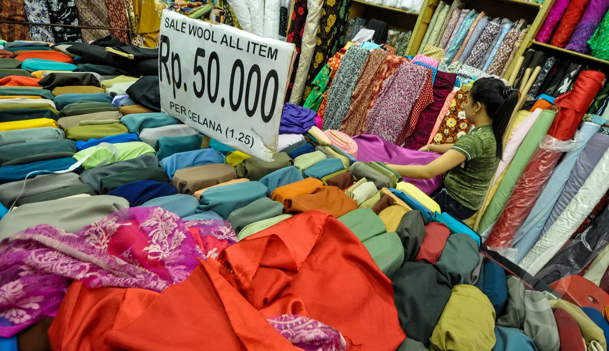 Pekerja merapikan kain lokal di Pasar Baru, Jakarta, Selasa (24/3/2015). Pengusaha tekstil nasional meminta Presiden Jokowi untuk melakukan kerja sama dengan Uni Eropa dan Turki agar bisa meningkatkan ekspor tekstil nasional.(Liputan6.com/Faizal Fanani)