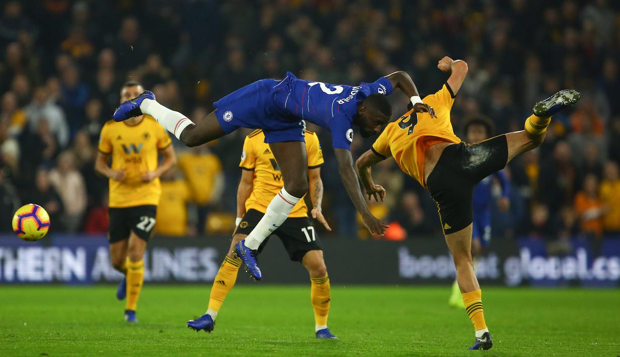 Bek Chelsea, Antonio Rudiger, berebut bola dengan striker Wolverhampton, Raul Jimenez, pada laga Premier League di Stadion Molineux Wolves, Kamis (5/12). Wolves menang 2-1 atas Chelsea. (AFP/Geoff Caddick)
