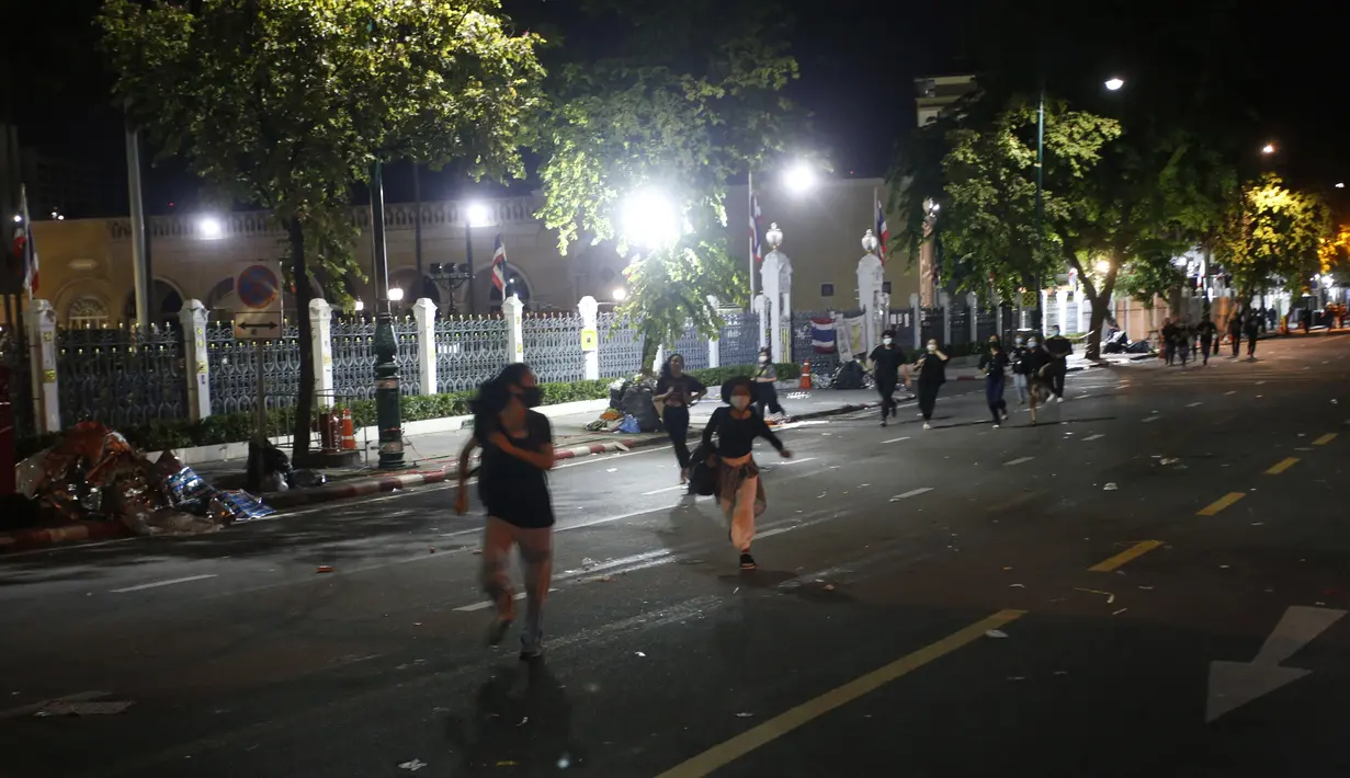 Demonstran pro-demokrasi melarikan diri dari polisi antihuru-hara saat demonstrasi di Bangkok, Thailand, Kamis (15/10/2020. Polisi Thailand membubarkan demonstran yang berunjuk rasa di luar kantor perdana menteri. (AP Photo)