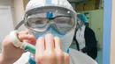 Petugas medis menggunakan selotip untuk merekatkan kaca mata pelindungnya di Rumah Sakit Tongji cabang Guanggu di Wuhan, 20 Februari 2020. Beberapa langkah pencegahan dilakukan secara ketat selama dan sesudah jam kerja oleh pekerja medis untuk membantu melawan virus corona. (Xinhua/Cai Yang)