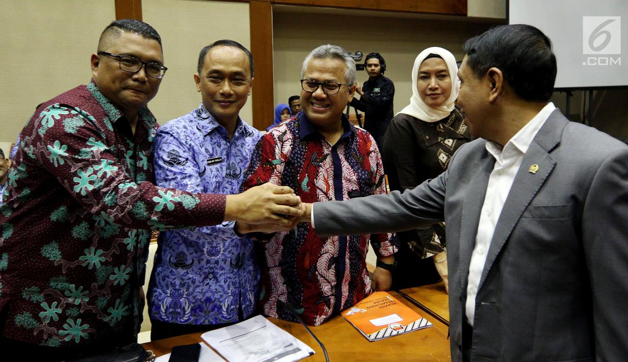 Ketua KPU Arief Budiman (tengah) berjabat tangan dengan Ketua Komisi II DPR Zainudin Amali (kanan), Dirjen Dukcapil Kemendagri Zudan Arif Fakrulloh (kedua kiri) sebelum mengikuti rapat di Senayan, Jakarta, Senin (21/5). (Liputan6.com/JohanTallo)
